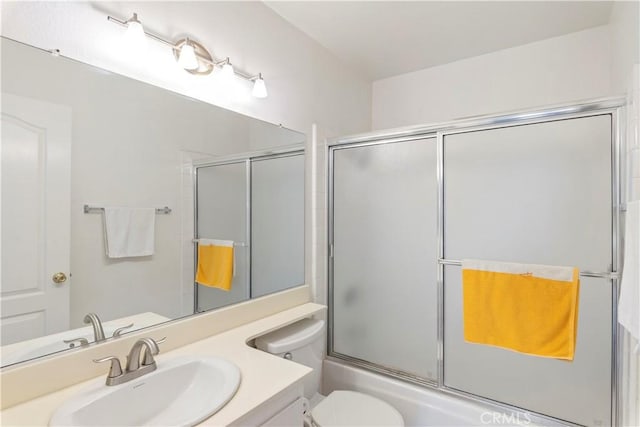 full bathroom featuring bath / shower combo with glass door, vanity, and toilet