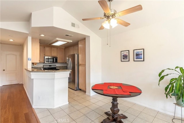 kitchen featuring lofted ceiling, light tile patterned floors, stainless steel appliances, and kitchen peninsula