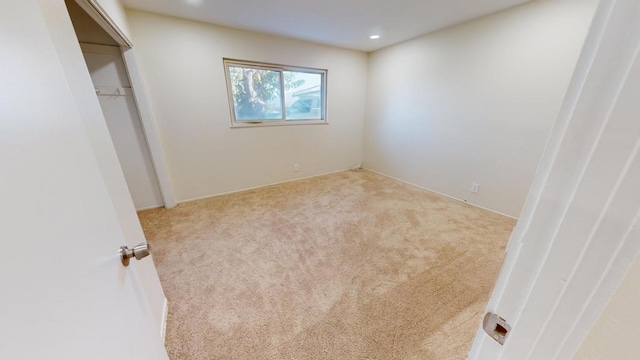 unfurnished bedroom featuring a closet and light carpet