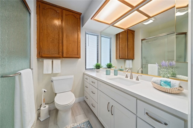 bathroom featuring a shower with door, vanity, and toilet