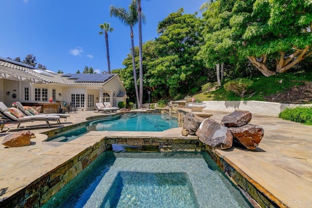 view of pool with french doors, an in ground hot tub, and a patio