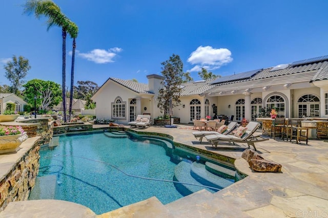 view of pool featuring french doors, a patio area, and a bar