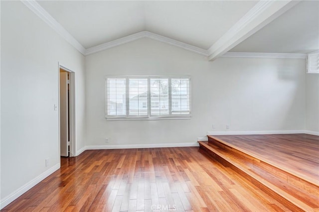 spare room featuring ornamental molding, lofted ceiling, and hardwood / wood-style floors