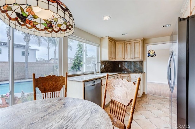 kitchen with light tile patterned floors, backsplash, and stainless steel appliances