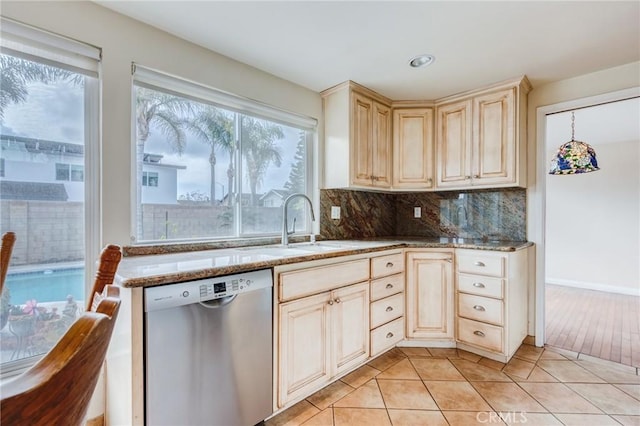 kitchen with dishwasher, light tile patterned flooring, light stone counters, and decorative backsplash