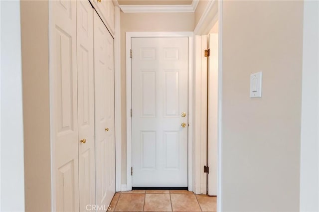 hall featuring light tile patterned flooring and ornamental molding