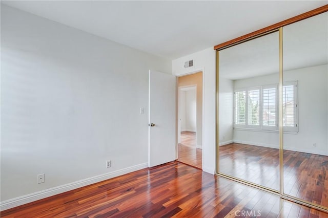 unfurnished bedroom with hardwood / wood-style floors and a closet