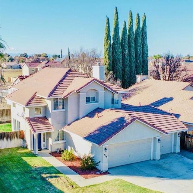 mediterranean / spanish home featuring a garage and a front yard