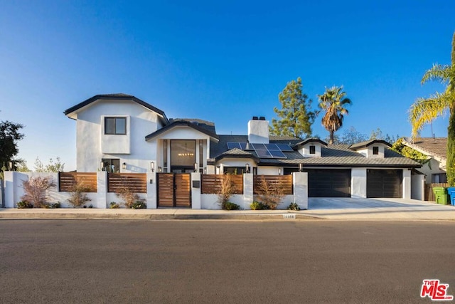 view of front of property with a garage and solar panels