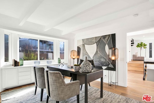 dining area with light hardwood / wood-style flooring and beamed ceiling