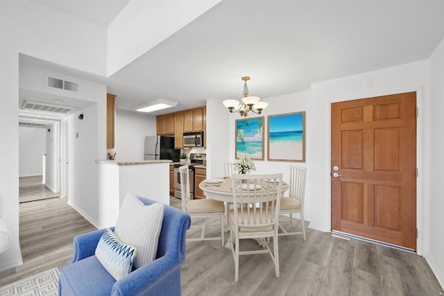 dining room featuring light hardwood / wood-style flooring and a notable chandelier