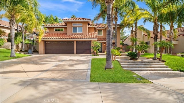 mediterranean / spanish-style house featuring a garage and a front lawn