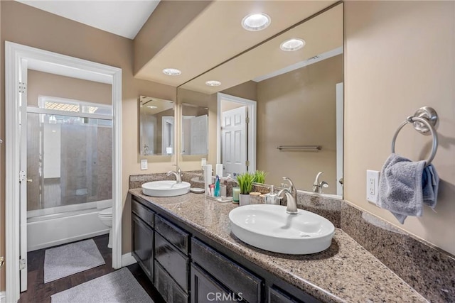 full bathroom featuring vanity, shower / bath combination with glass door, and toilet