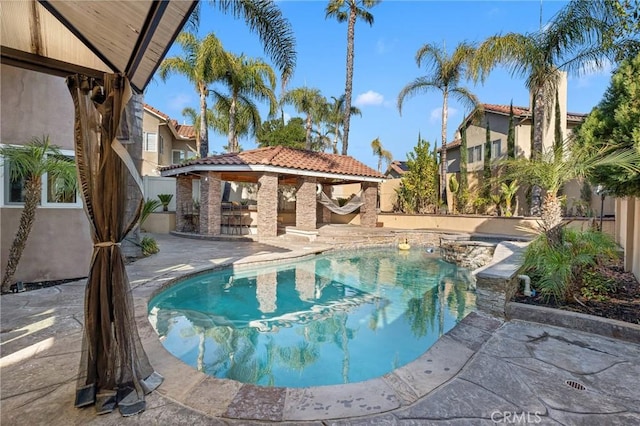 view of swimming pool featuring a gazebo, a bar, and a patio area