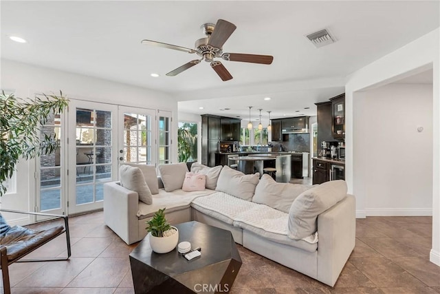 living room featuring light tile patterned flooring, ceiling fan, and french doors