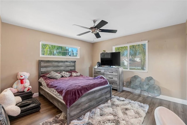 bedroom featuring multiple windows, hardwood / wood-style floors, and ceiling fan