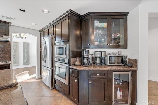 kitchen featuring wine cooler, dark brown cabinetry, stainless steel appliances, and light tile patterned flooring