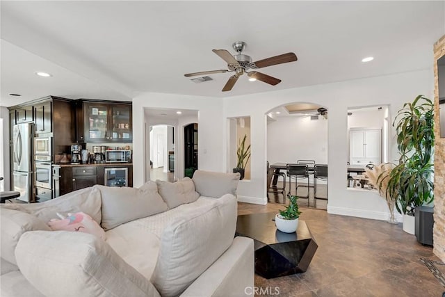 living room featuring bar, wine cooler, and ceiling fan