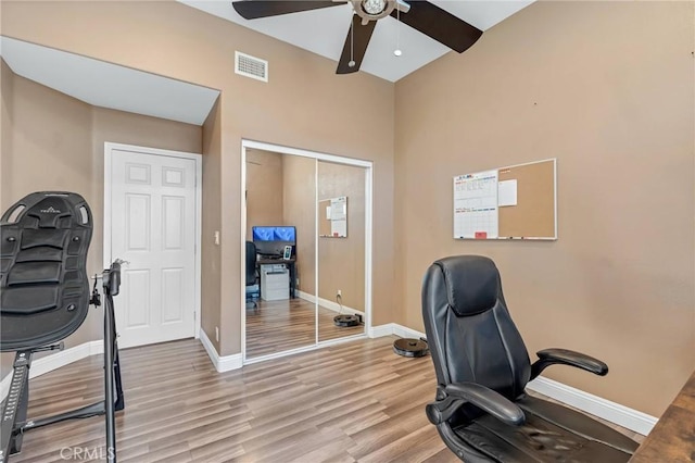 home office with ceiling fan and light hardwood / wood-style flooring