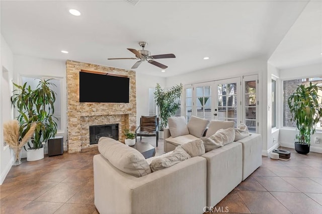 tiled living room featuring french doors, ceiling fan, and a fireplace