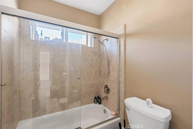 bathroom featuring shower / bath combination with glass door and toilet