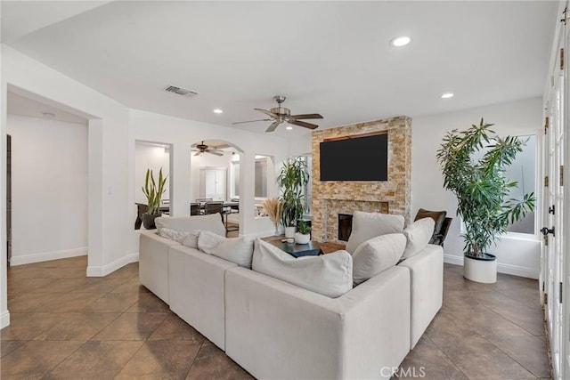 living room featuring ceiling fan and a fireplace