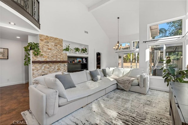 living room with beamed ceiling, a notable chandelier, and high vaulted ceiling