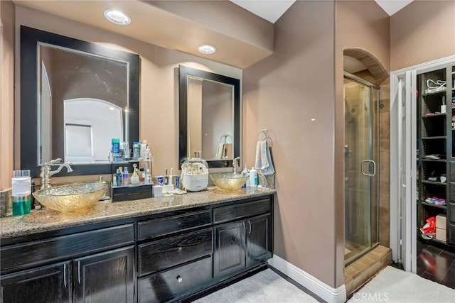 bathroom featuring vanity and a shower with door