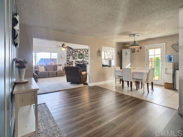 dining room featuring ceiling fan, a textured ceiling, and wood finished floors