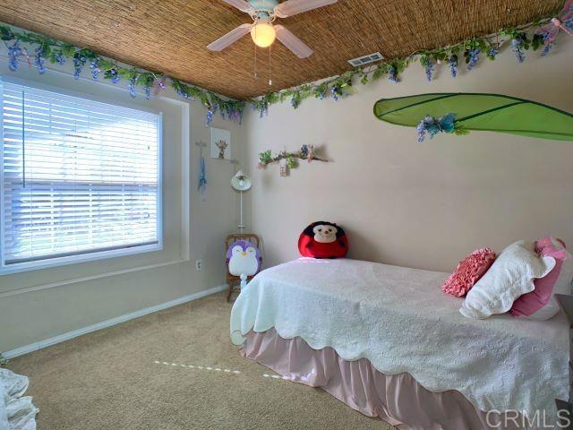 bedroom featuring baseboards, visible vents, ceiling fan, and carpet flooring