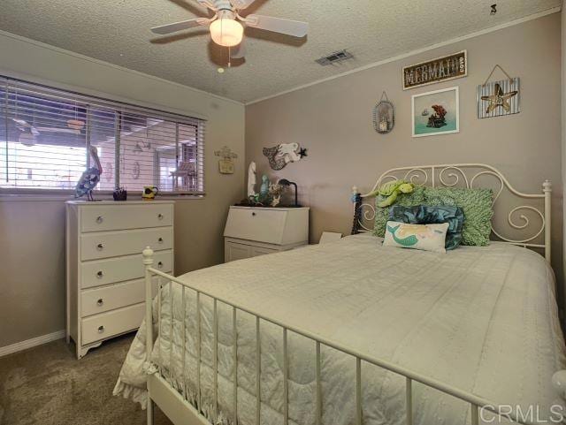 bedroom featuring baseboards, visible vents, ornamental molding, a textured ceiling, and carpet flooring