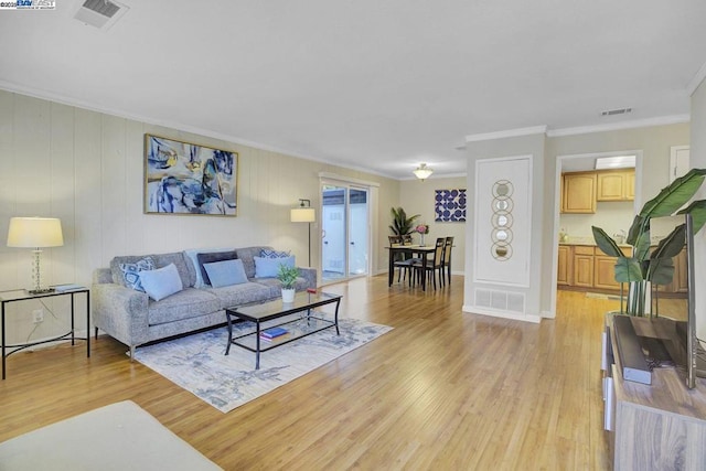 living room with crown molding and light hardwood / wood-style flooring