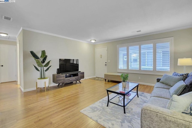 living room featuring crown molding and light hardwood / wood-style flooring