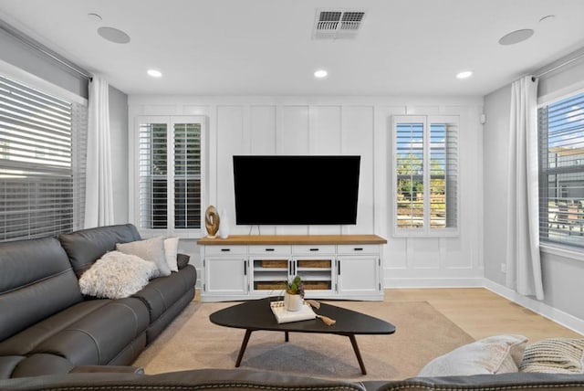 living room with a healthy amount of sunlight and light hardwood / wood-style flooring