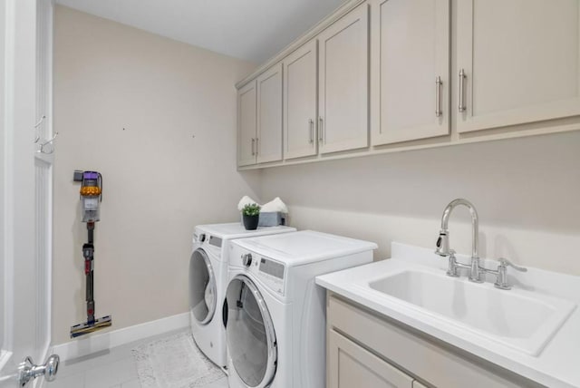 clothes washing area with cabinets, sink, light tile patterned floors, and independent washer and dryer