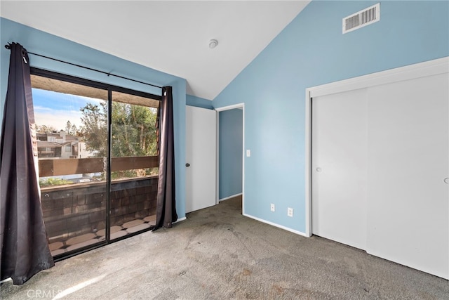 unfurnished bedroom featuring a closet, access to exterior, high vaulted ceiling, and carpet