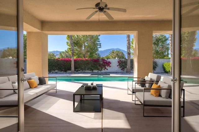 view of pool featuring a mountain view, an outdoor hangout area, ceiling fan, and a patio area