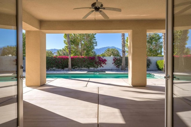 view of pool with a mountain view, a patio, and ceiling fan