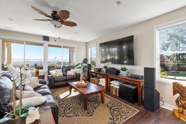 living room featuring ceiling fan, dark hardwood / wood-style floors, and a wealth of natural light