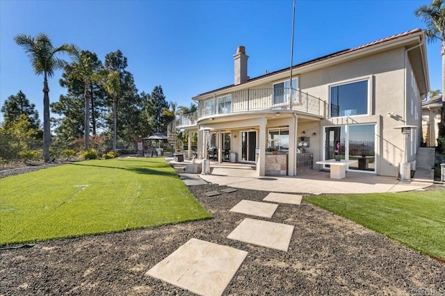 back of house featuring a balcony, a yard, and a patio area