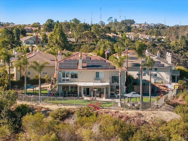 rear view of property with solar panels