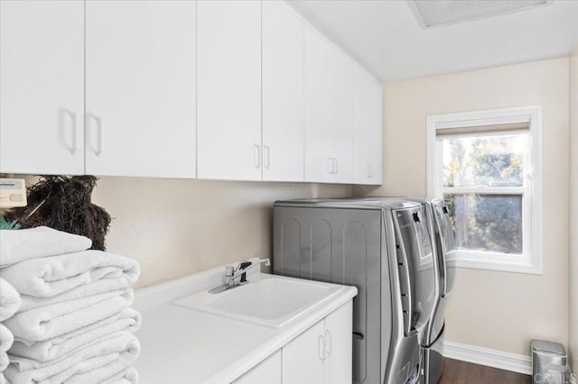 washroom featuring dark wood-type flooring, cabinets, separate washer and dryer, and sink