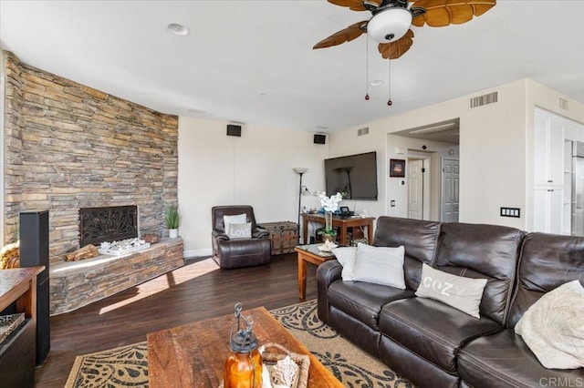 living room featuring ceiling fan, dark hardwood / wood-style floors, and a fireplace