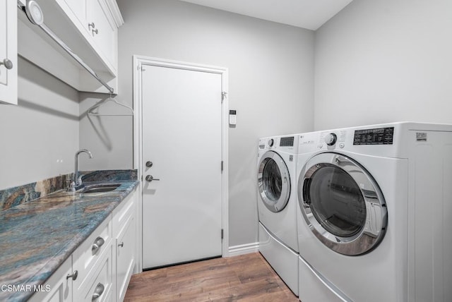 washroom with cabinets, separate washer and dryer, sink, and dark hardwood / wood-style flooring