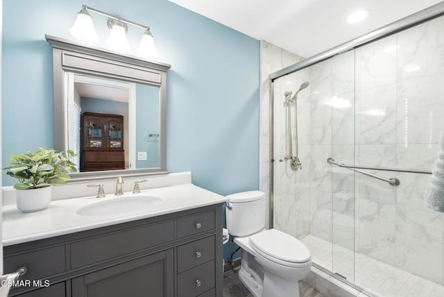 bathroom with walk in shower, vanity, and toilet