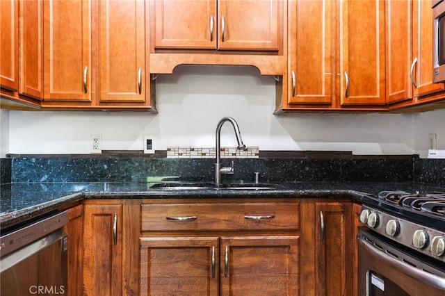 kitchen featuring sink, dark stone counters, and appliances with stainless steel finishes