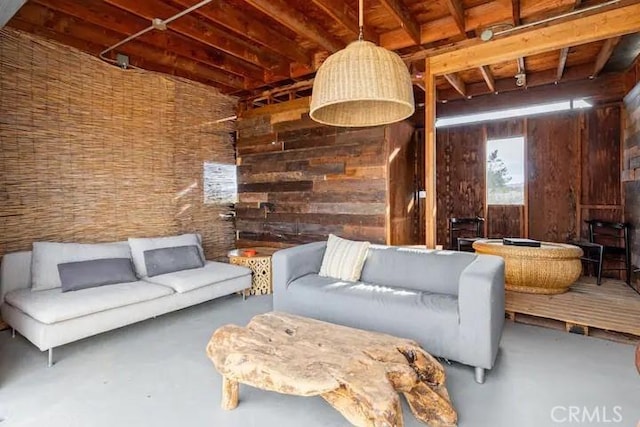 unfurnished living room featuring concrete floors and wood walls