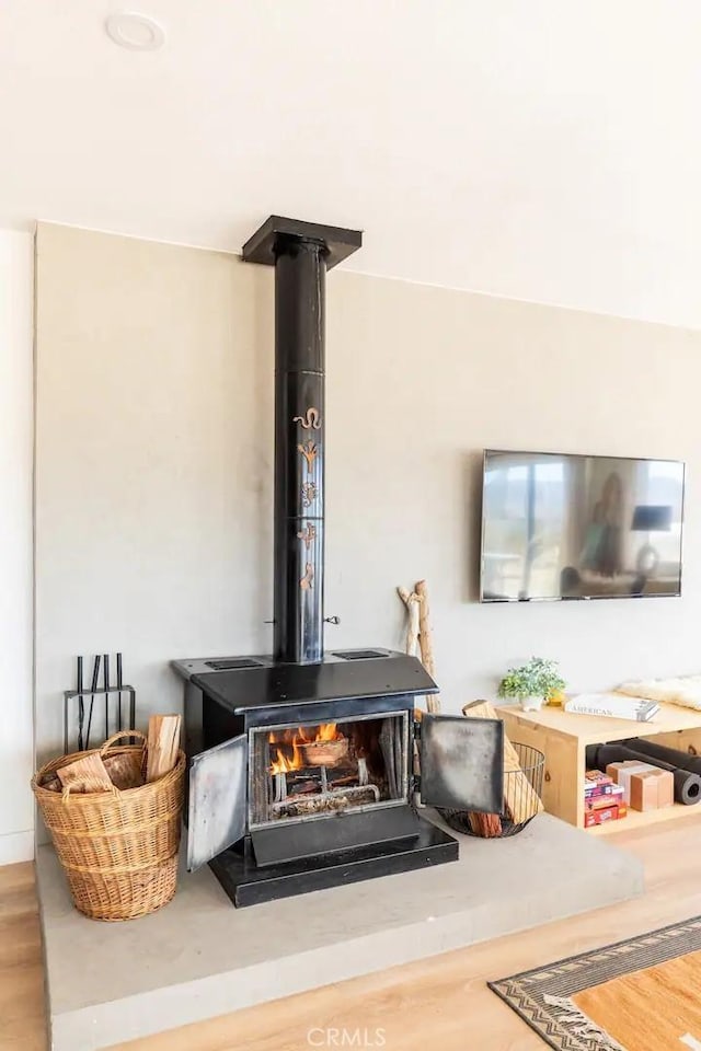 interior details with a wood stove and hardwood / wood-style floors