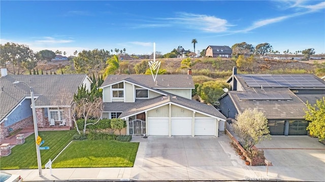 view of front of property with a garage, solar panels, and a front lawn