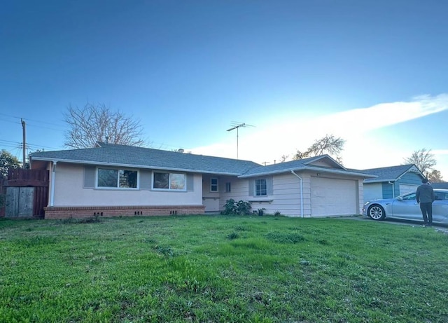 single story home with a garage and a front lawn